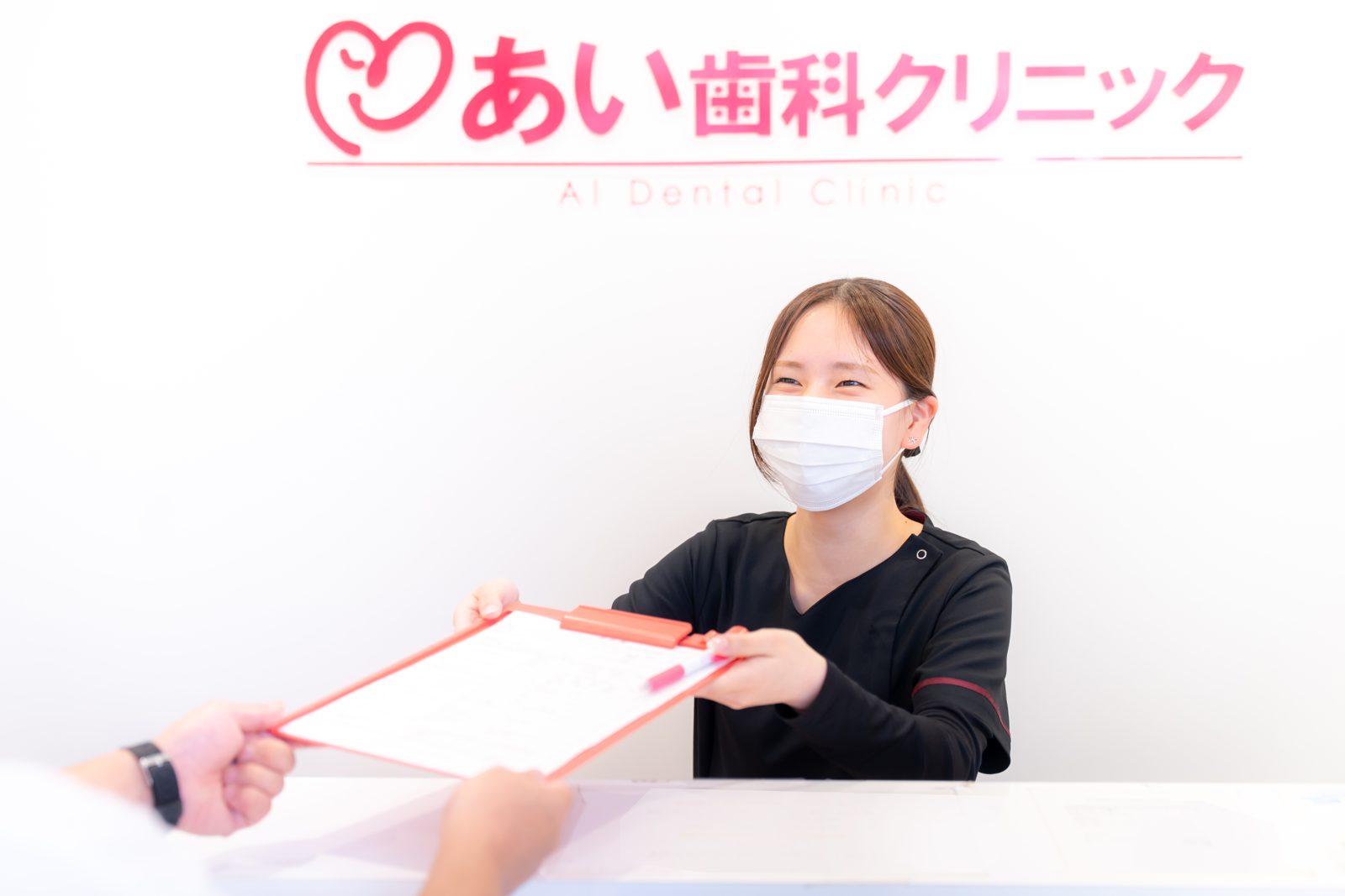 担当のスタッフが問診票をお預かりする様子
